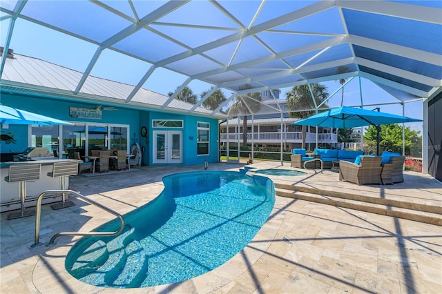 view of swimming pool featuring french doors, a lanai, outdoor lounge area, ceiling fan, and a patio area