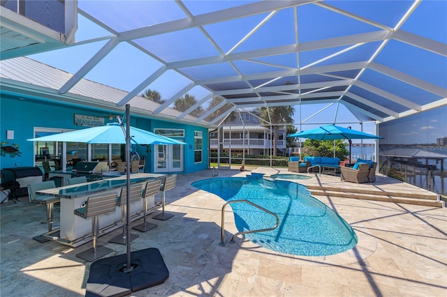 view of swimming pool featuring area for grilling, a lanai, outdoor lounge area, a bar, and a patio