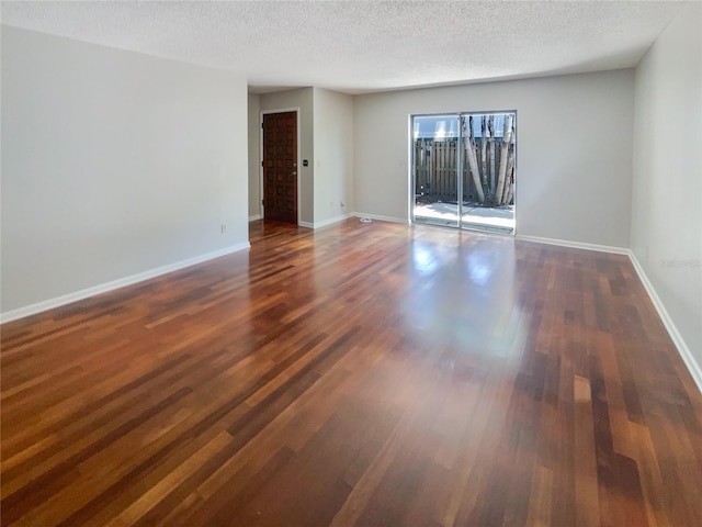 empty room featuring dark hardwood / wood-style flooring and a textured ceiling