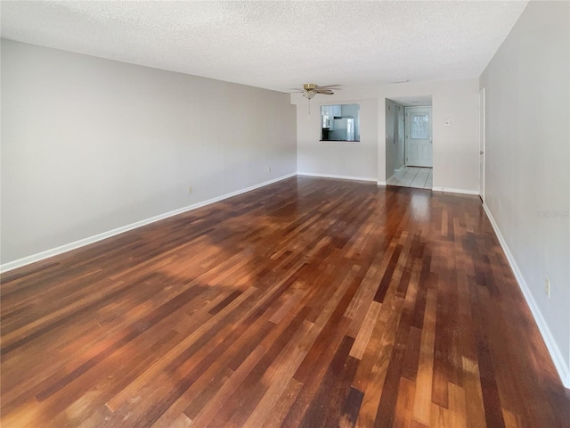 unfurnished room featuring a textured ceiling and dark hardwood / wood-style floors