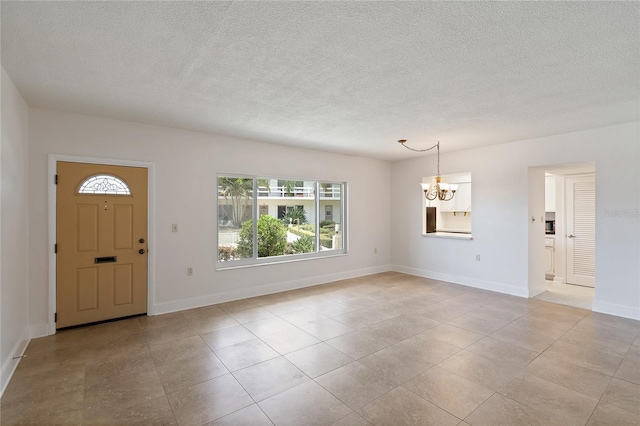 foyer featuring a textured ceiling and a chandelier