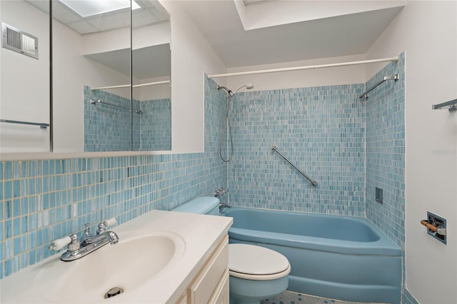 full bathroom with vanity, tiled shower / bath, decorative backsplash, toilet, and tile walls