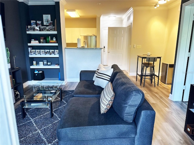 living room featuring light hardwood / wood-style floors and crown molding