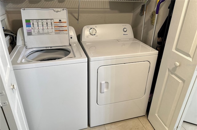 laundry area with washer hookup, light tile floors, and washing machine and clothes dryer