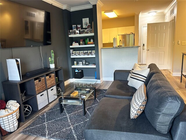 living room with ornamental molding and wood-type flooring