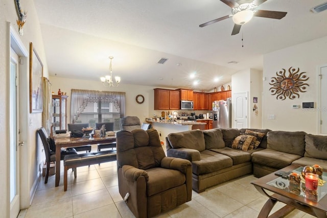 tiled living room featuring lofted ceiling and ceiling fan with notable chandelier