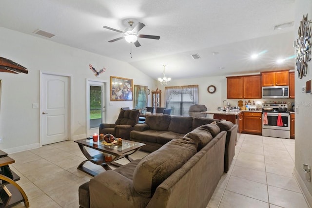 living room with ceiling fan with notable chandelier, light tile patterned flooring, sink, and vaulted ceiling