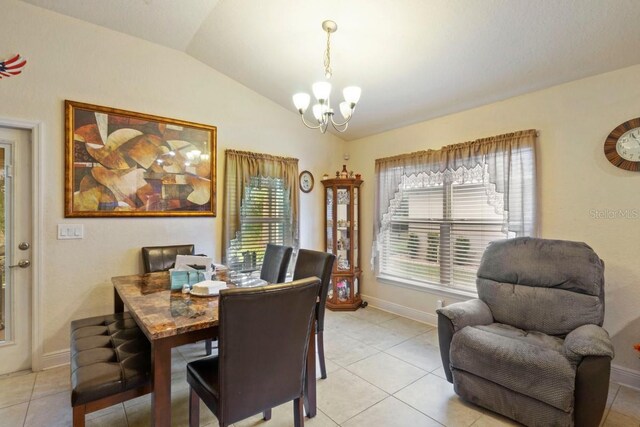 dining space with light tile patterned floors, lofted ceiling, and an inviting chandelier