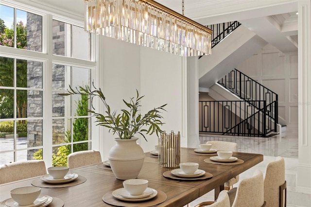 dining room with a decorative wall, stairway, and an inviting chandelier