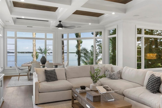 sunroom / solarium with beam ceiling, coffered ceiling, ceiling fan, and a water view