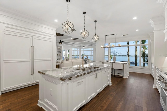 kitchen featuring dark wood finished floors, a water view, and white cabinetry