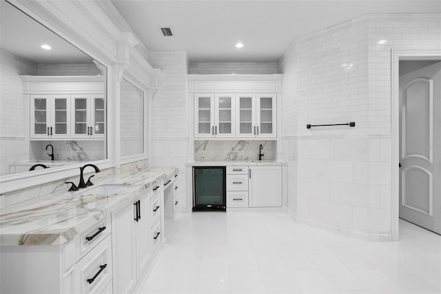 interior space with vanity, beverage cooler, visible vents, recessed lighting, and tile walls