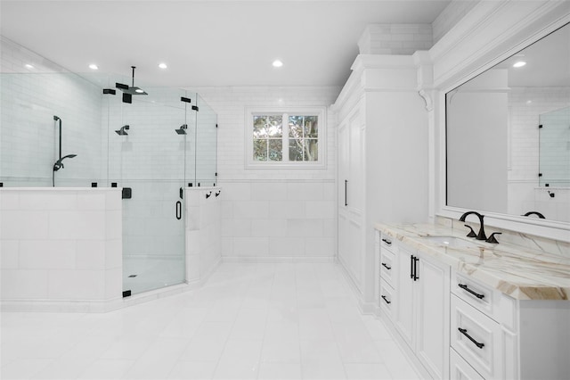 bathroom with a shower with door and vanity