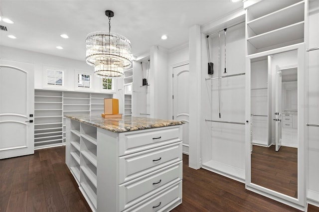 spacious closet featuring visible vents, dark wood finished floors, and a chandelier