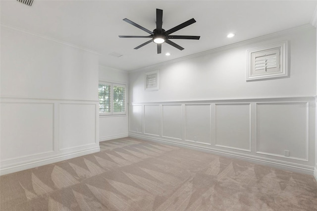 spare room featuring light carpet, crown molding, and ceiling fan