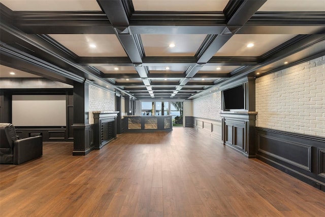 interior space featuring beam ceiling, brick wall, coffered ceiling, and a large fireplace