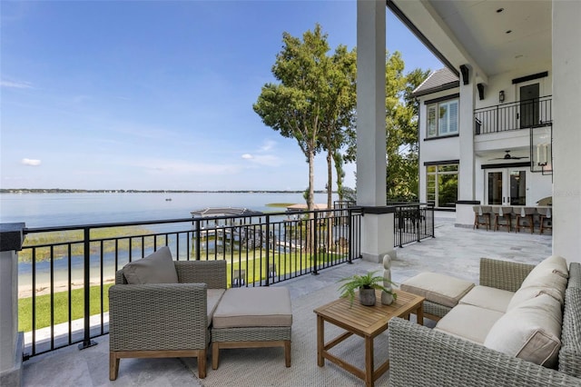 view of patio featuring a bar, an outdoor hangout area, a water view, and a balcony