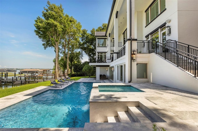 pool with an in ground hot tub and a patio