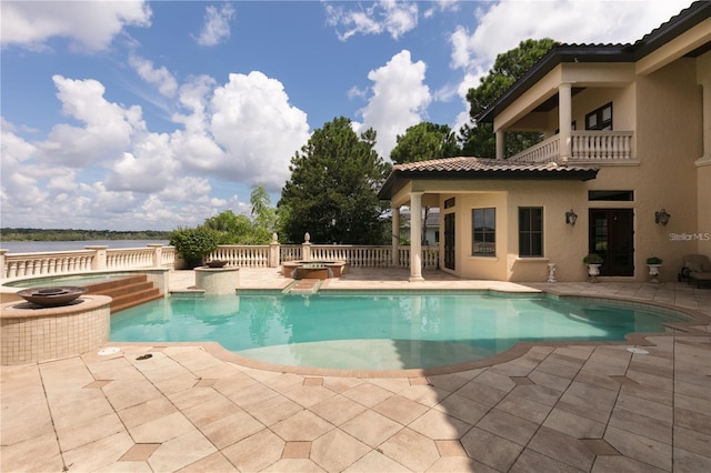 view of swimming pool featuring a patio area, an in ground hot tub, a water view, and pool water feature