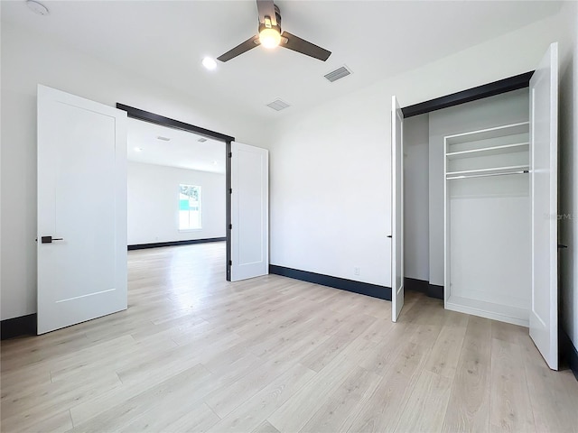 unfurnished bedroom with ceiling fan, light hardwood / wood-style floors, and a closet