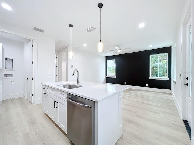 kitchen with white cabinets, a center island with sink, sink, stainless steel dishwasher, and light hardwood / wood-style floors