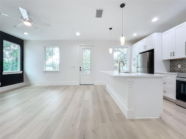 kitchen with backsplash, white cabinetry, sink, and stainless steel appliances