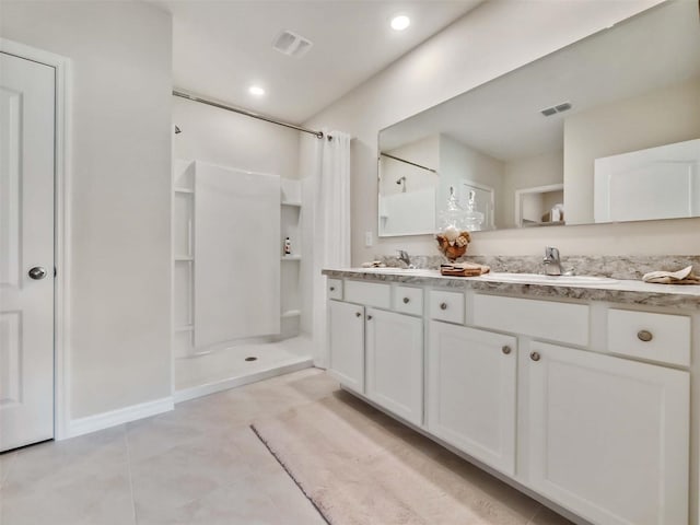 bathroom featuring tile patterned flooring, vanity, and walk in shower