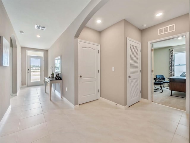 hall with light tile patterned floors