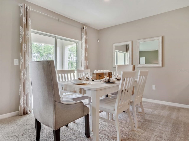 dining space featuring light carpet