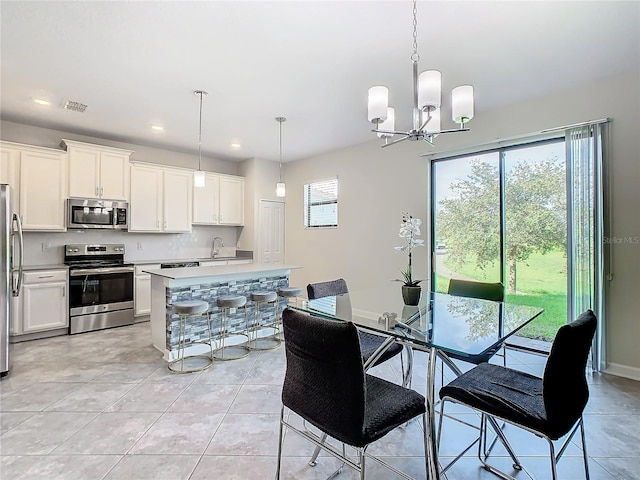 dining room featuring a notable chandelier, light tile patterned flooring, and sink