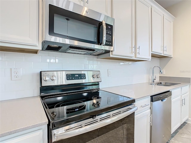 kitchen with sink, appliances with stainless steel finishes, decorative backsplash, and white cabinets