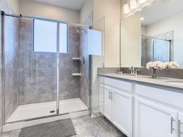 bathroom featuring a shower with door, vanity, and tile patterned floors