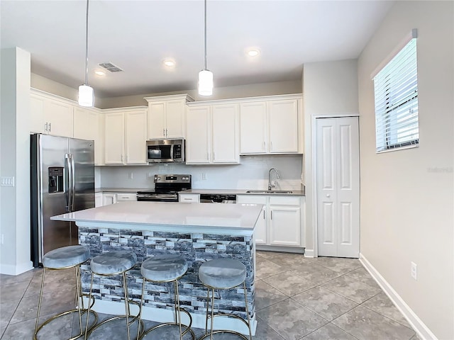 kitchen with a center island, stainless steel appliances, sink, and pendant lighting