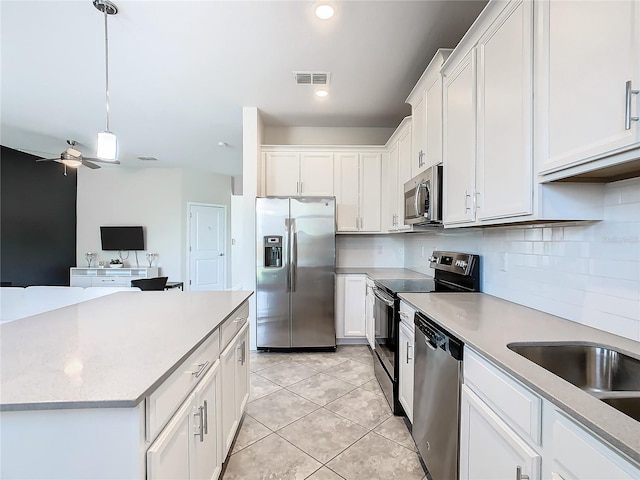 kitchen featuring white cabinets, tasteful backsplash, ceiling fan, light tile patterned floors, and stainless steel appliances