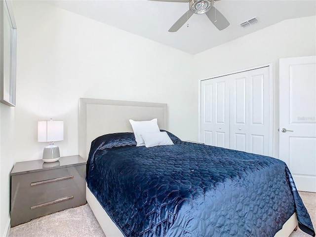 bedroom with a closet, ceiling fan, light carpet, and lofted ceiling