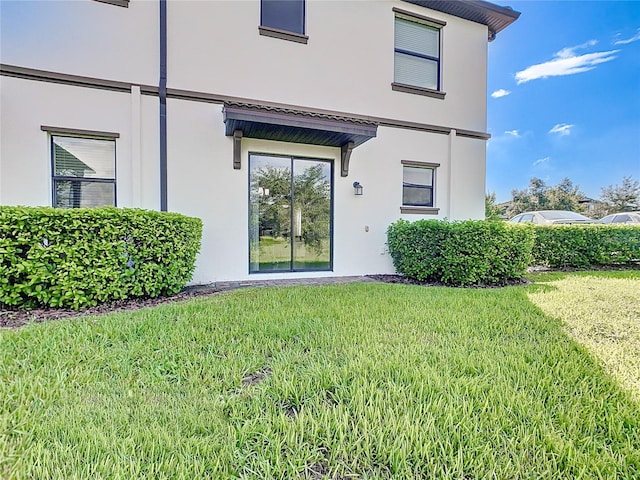 property entrance featuring a lawn