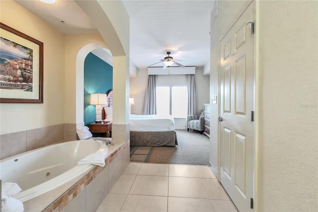 bathroom featuring tile patterned floors, ceiling fan, and a relaxing tiled tub