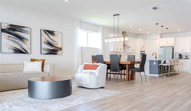 living room with sink and light hardwood / wood-style flooring