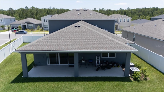 rear view of property with a patio and a lawn