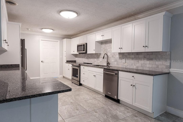 kitchen featuring white cabinets, sink, ornamental molding, appliances with stainless steel finishes, and kitchen peninsula