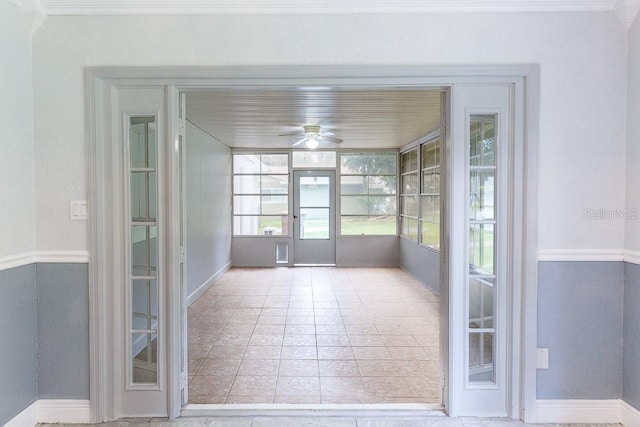 unfurnished sunroom featuring ceiling fan