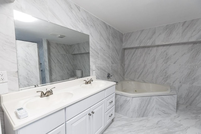 bathroom featuring vanity, toilet, and a tub to relax in