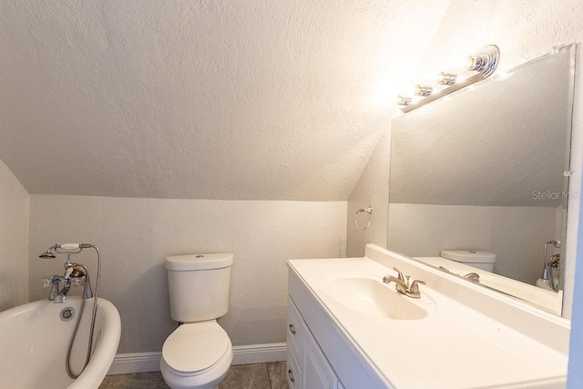 bathroom with toilet, vanity, a tub to relax in, and vaulted ceiling