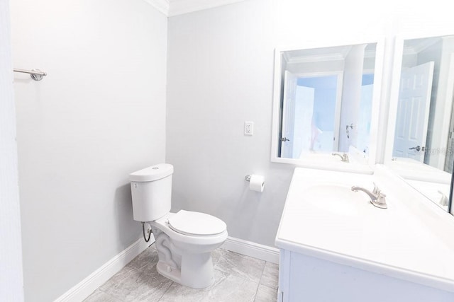 bathroom with vanity, toilet, and ornamental molding