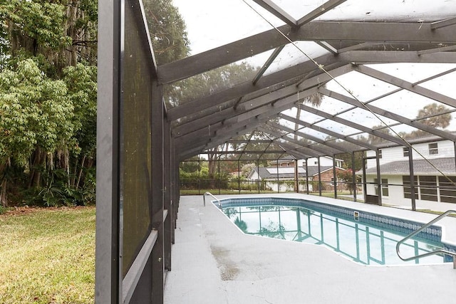 view of swimming pool featuring a lanai and a yard