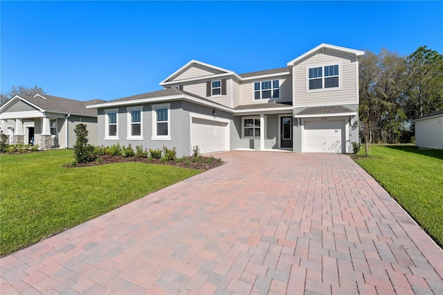 view of front of house with an attached garage, decorative driveway, and a front yard