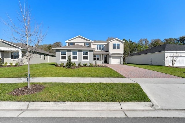 view of front of property with an attached garage, a front lawn, and decorative driveway