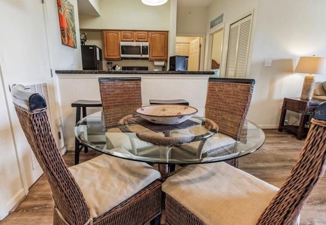 dining space featuring light wood-style flooring and baseboards