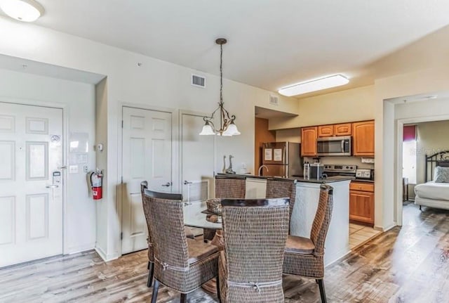 dining room featuring visible vents and light wood-style flooring