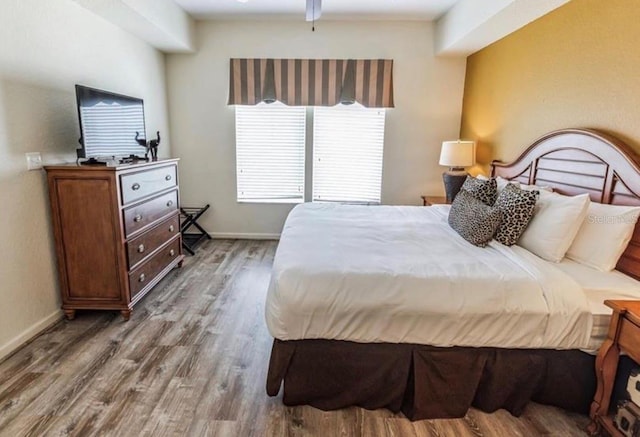 bedroom featuring wood finished floors and baseboards